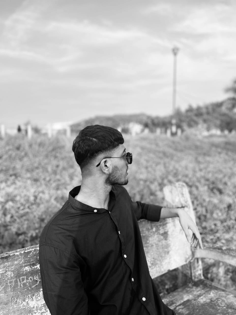 ashuthosh Digital Marketing Expert in Kochi ashuthosh - black-and-white portrait featuring the same individual seated on a wooden bench, with the person looking away from the camera toward the open scenery.