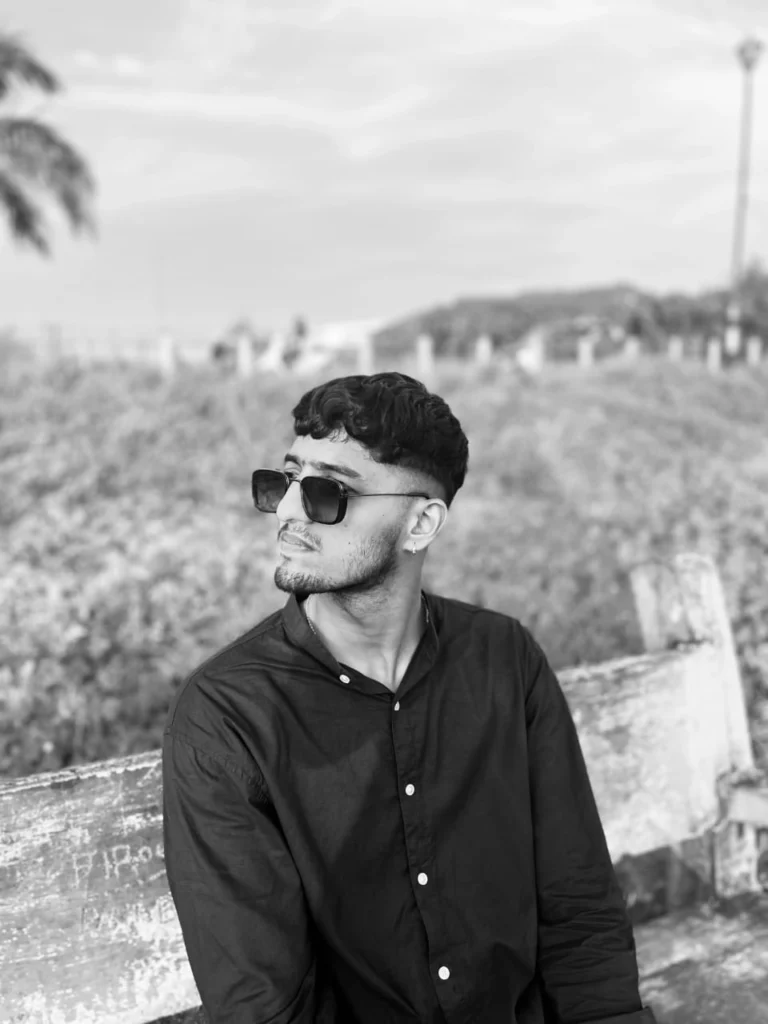 Digital Marketing Expert in Kochi ashuthosh-  black-and-white image of the same person sitting on a bench, with the individual looking slightly upward and to the side.